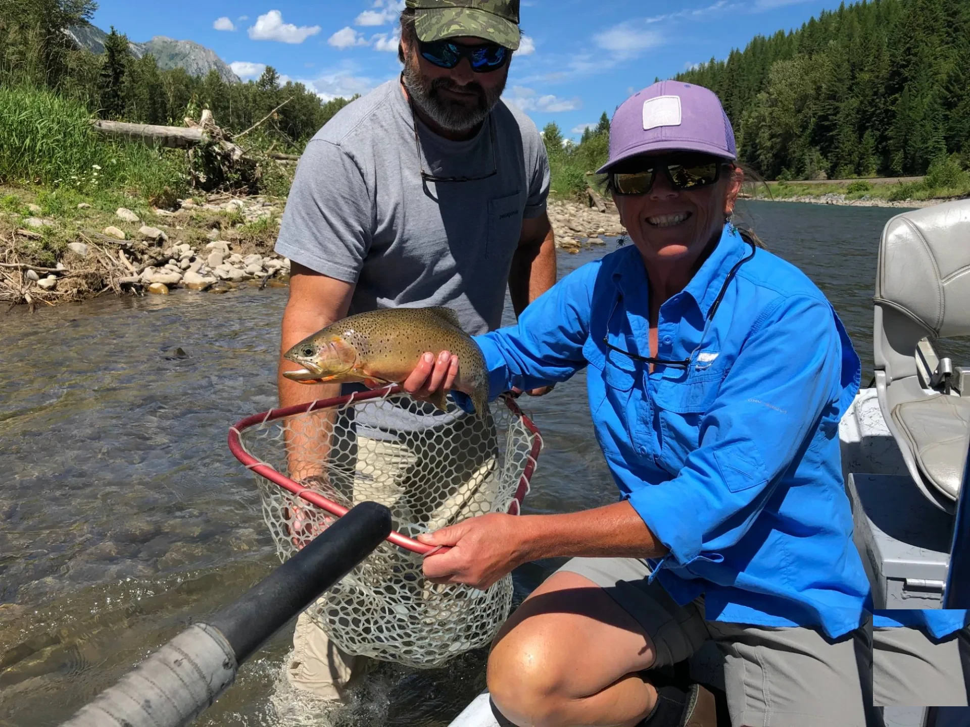 Couple holding a cutthroat trout in a drift boat on the Elk River near Fernie BC